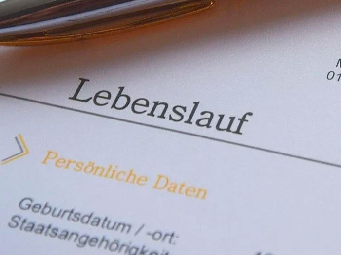 Gros plan sur un CV en allemand avec l'en-tête 'Lebenslauf' (CV), symbolisant la transformation et l'amélioration professionnelle de Méghane après une consultation avec Kris Saint Ange.