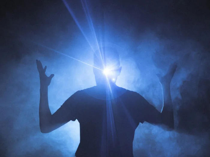 Cette image représente une personne enveloppée de fumée bleue, avec une lumière intense émanant de sa tête, symbolisant le potentiel humain et l'énergie intuitive abordées dans l'article sur le développement durable. Ce visuel illustre la puissance de l'énergie humaine pour transformer et guider des stratégies de développement durable, mettant en lumière la capacité humaine à transcender les défis par l'innovation et la créativité.