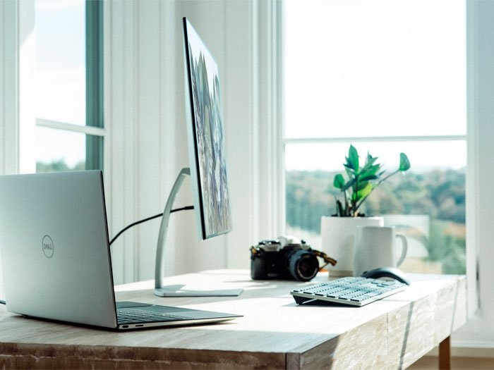 Bureau moderne et lumineux équipé d'un ordinateur portable et d'un écran, un espace de travail serein symbolisant la nouvelle phase de vie professionnelle réussie après des consultations bénéfiques.